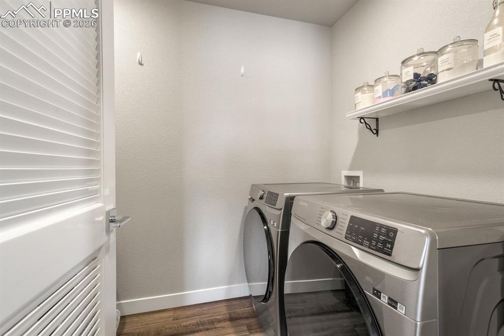 Laundry area featuring separate washer and dryer and dark wood-style floors
