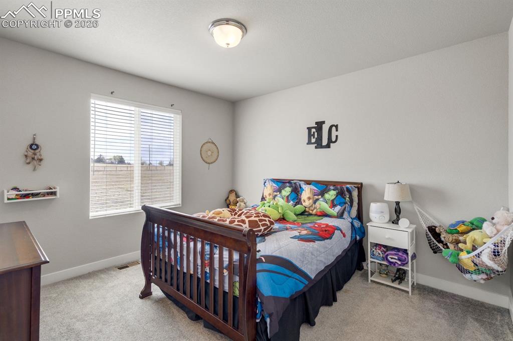 Bedroom with light carpet and baseboards