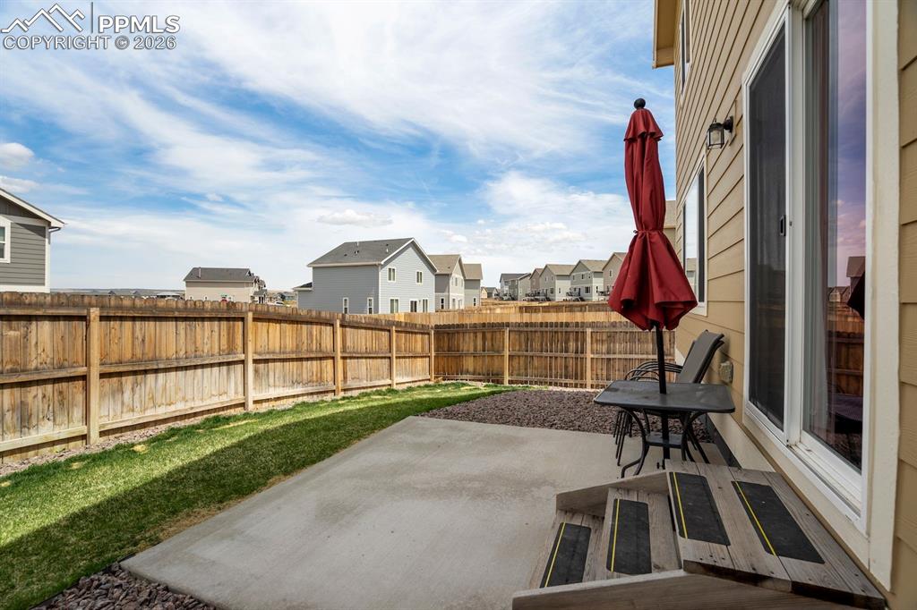 Fenced backyard featuring a patio and a residential view