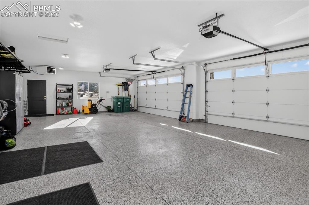 Heated 4-car attached garage with epoxy floors, hot & cold water and power washer
