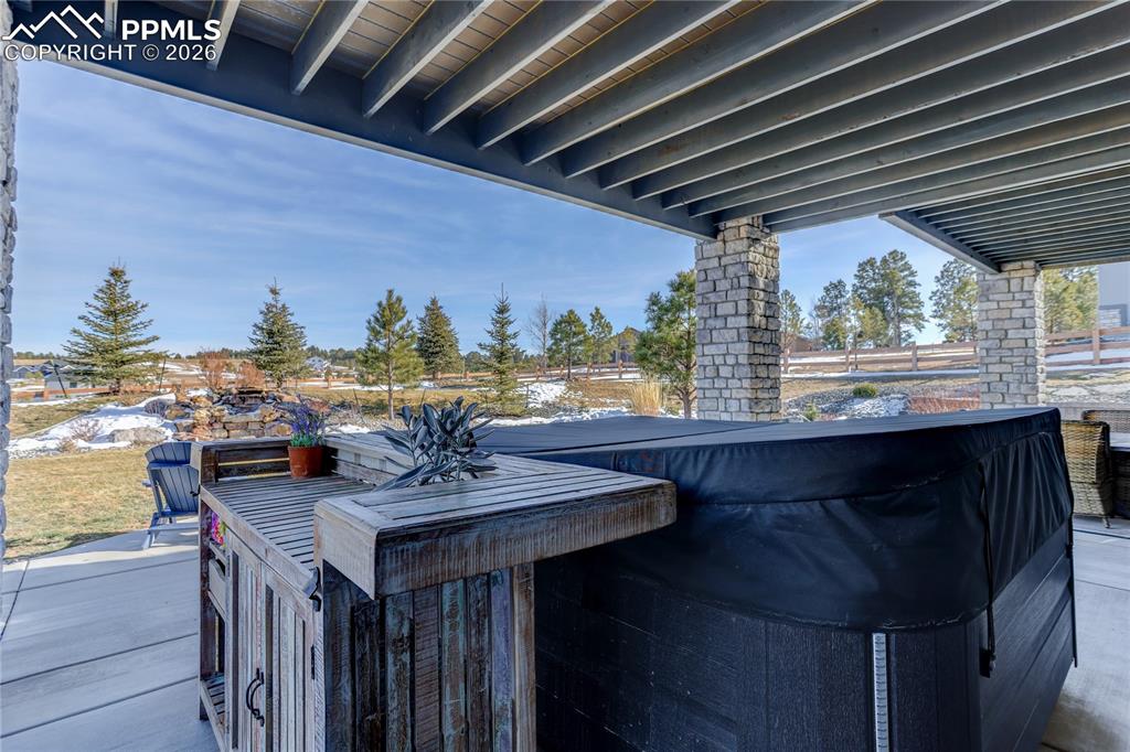 Lower-level covered patio area with 8-person hot tub