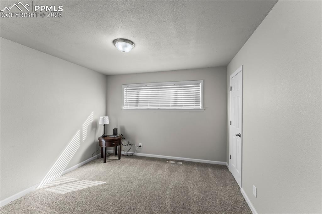 Empty room featuring carpet and a textured ceiling
