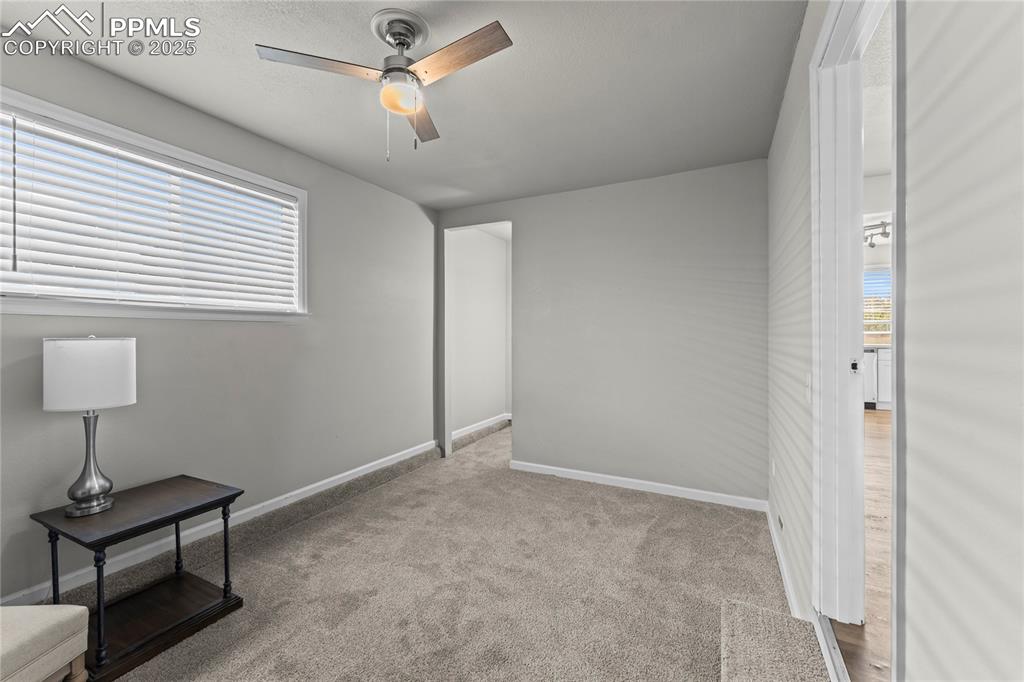 Unfurnished bedroom with light carpet and ceiling fan