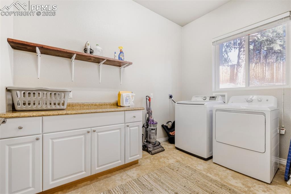 Main Laundry room featuring separate washer and dryer and cabinet space