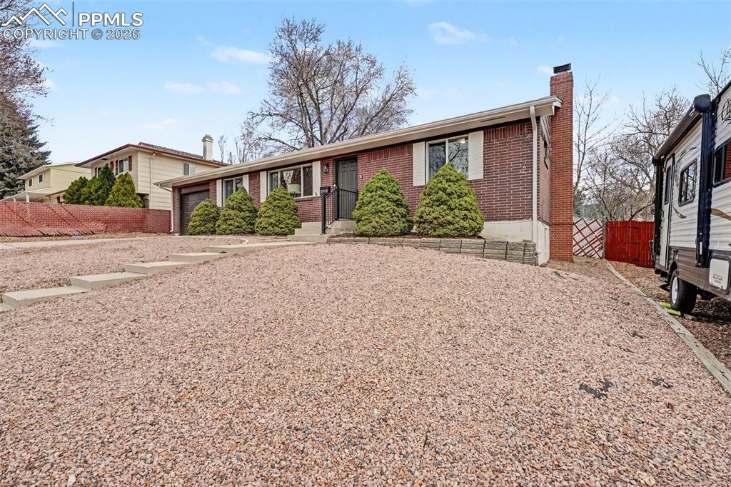 Single story home with a chimney and brick siding