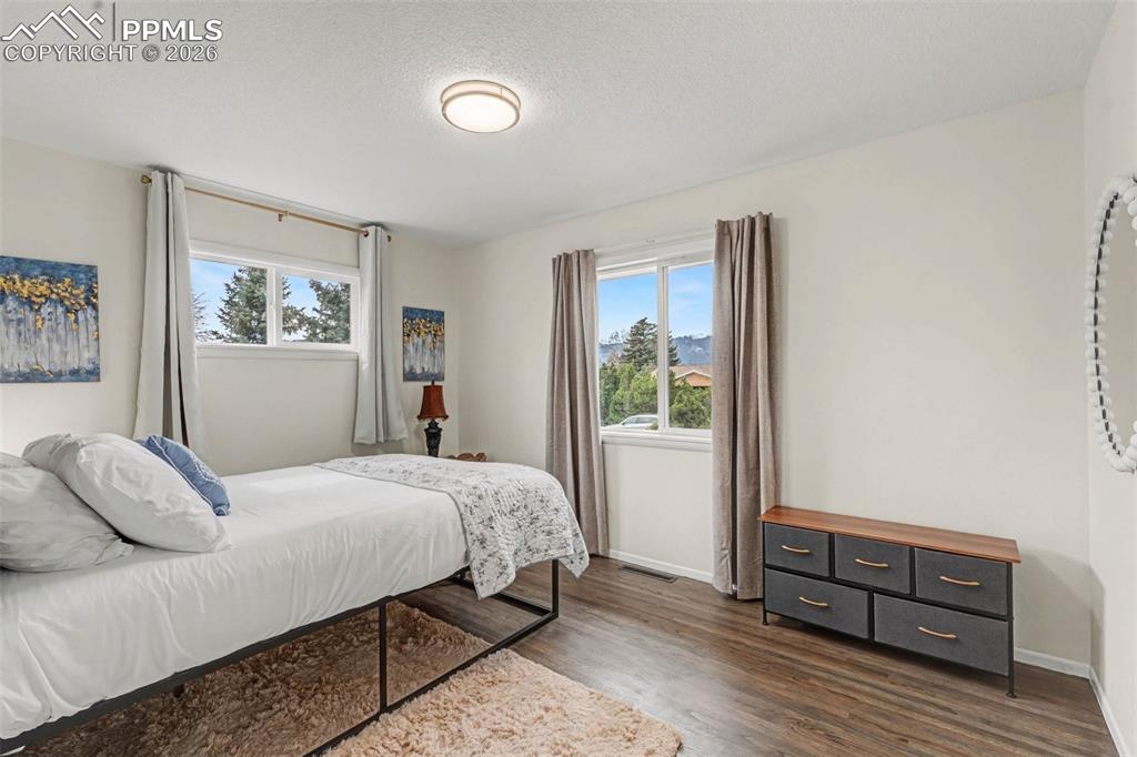 Bedroom with dark wood finished floors and a textured ceiling