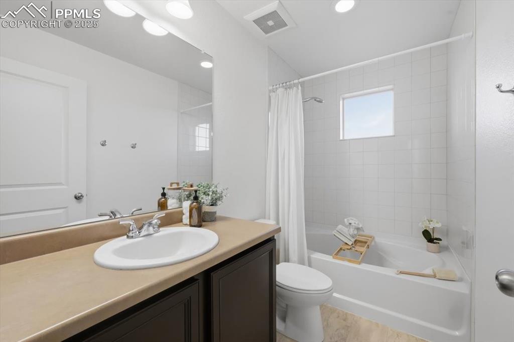 Full bathroom with shower / bath combo with shower curtain, vanity, and recessed lighting