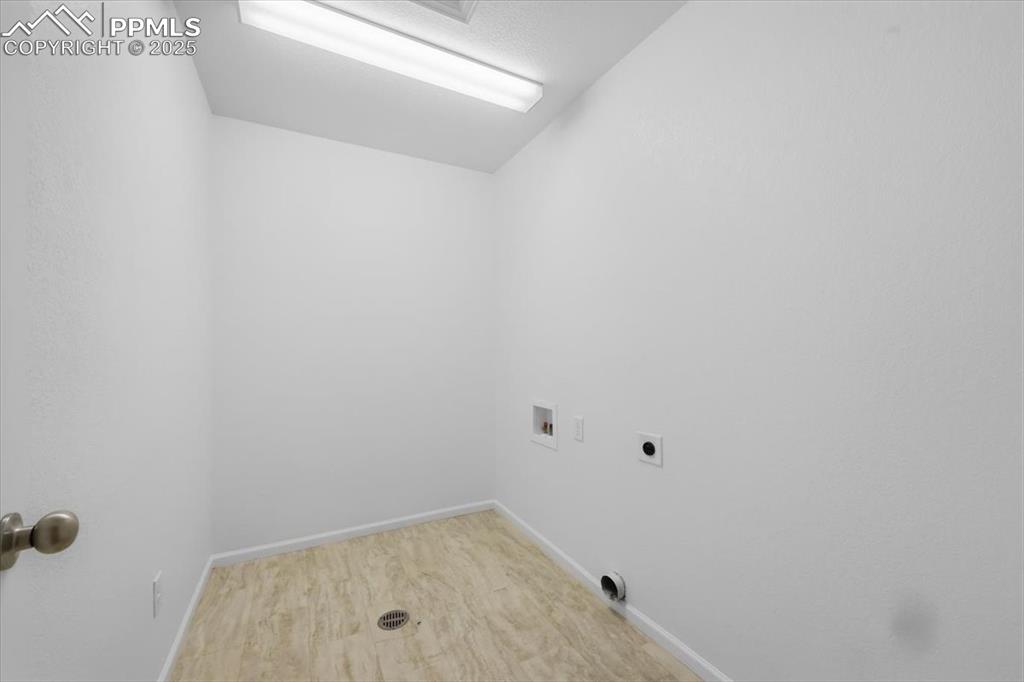 Laundry room with washer hookup, electric dryer hookup, and wood finished floors