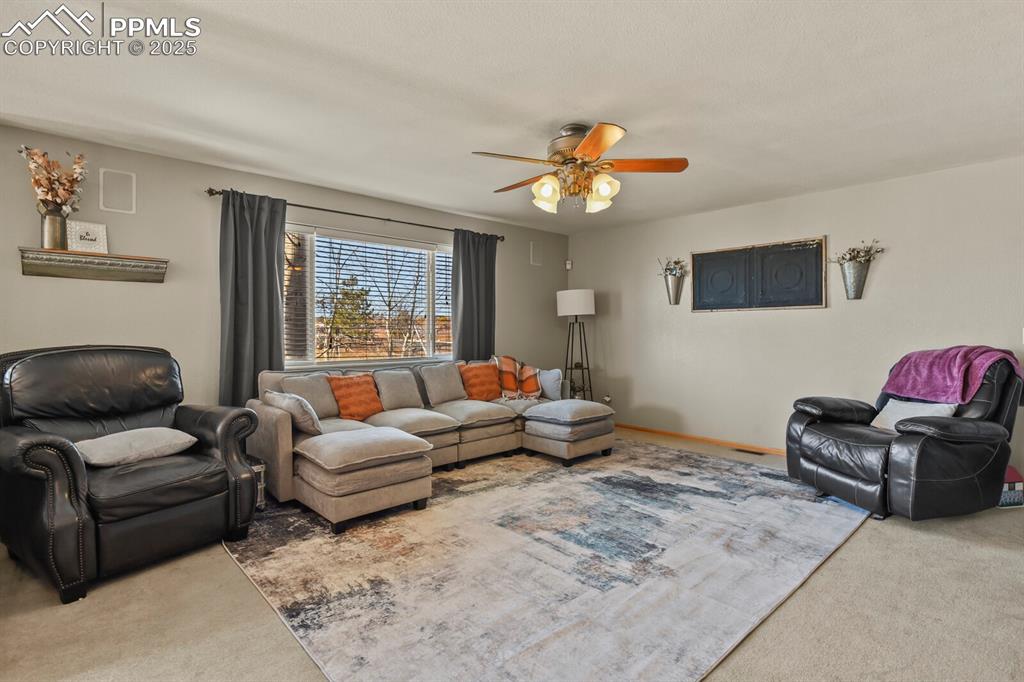 Living room featuring carpet floors and a ceiling fan