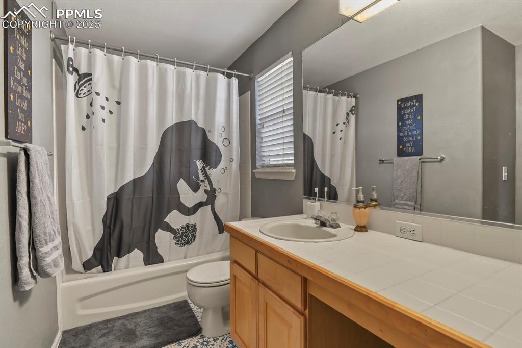 Full bathroom featuring shower / bath combo with shower curtain and vanity