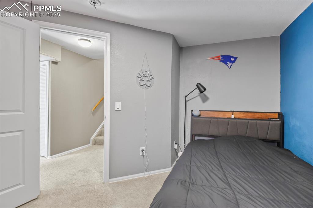 Bedroom with light colored carpet and baseboards