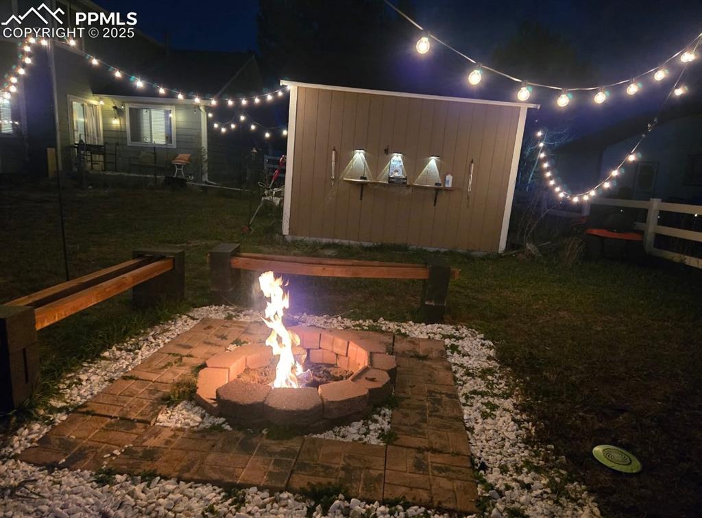 Yard at night featuring a patio area and a lawn