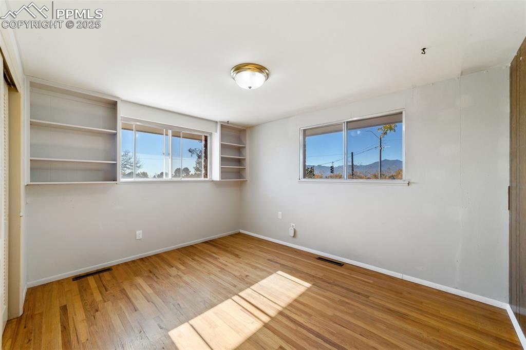 Empty room with light wood-type flooring and a mountain view
