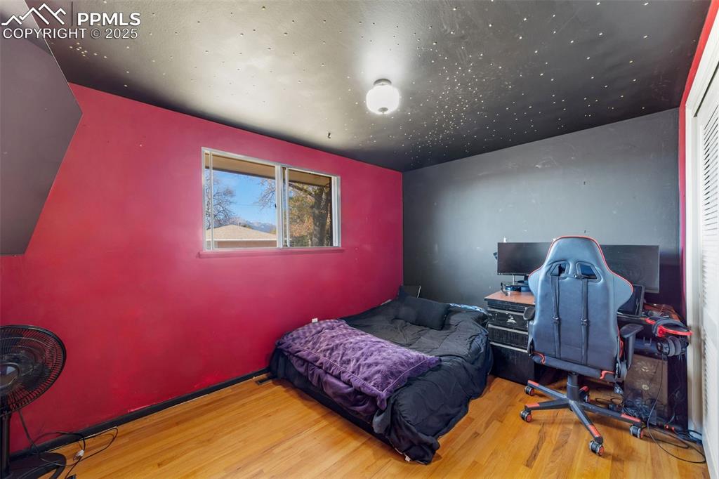 Bedroom with wood finished floors and a desk