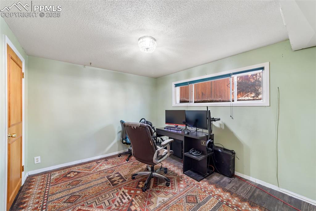 Office space with a textured ceiling and wood finished floors