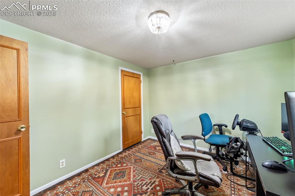 Office area with a textured ceiling and baseboards