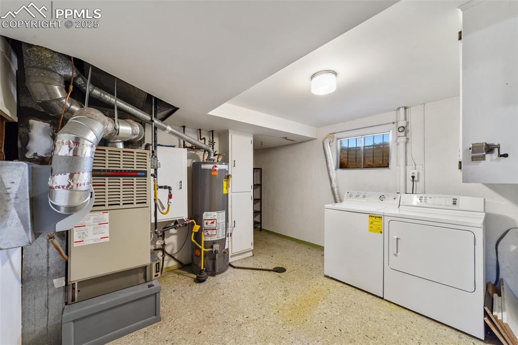 Laundry area featuring gas water heater, washer and clothes dryer, and heating unit