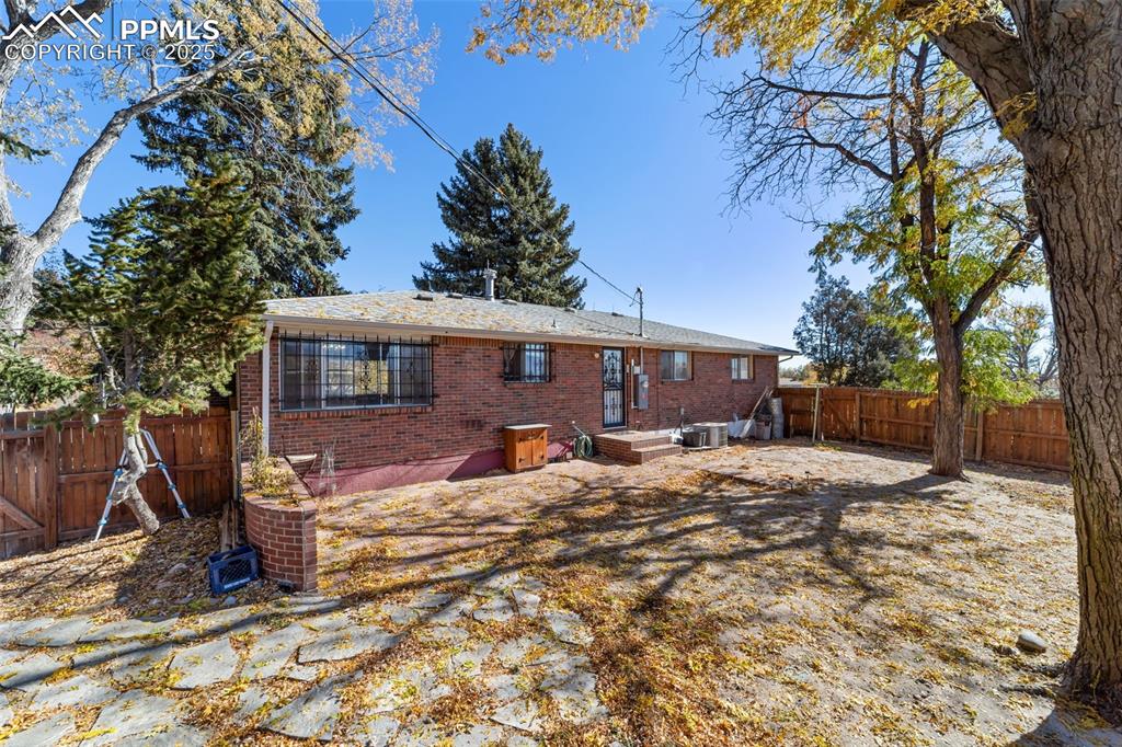 Rear view of house with a patio area, a fenced backyard, and brick siding