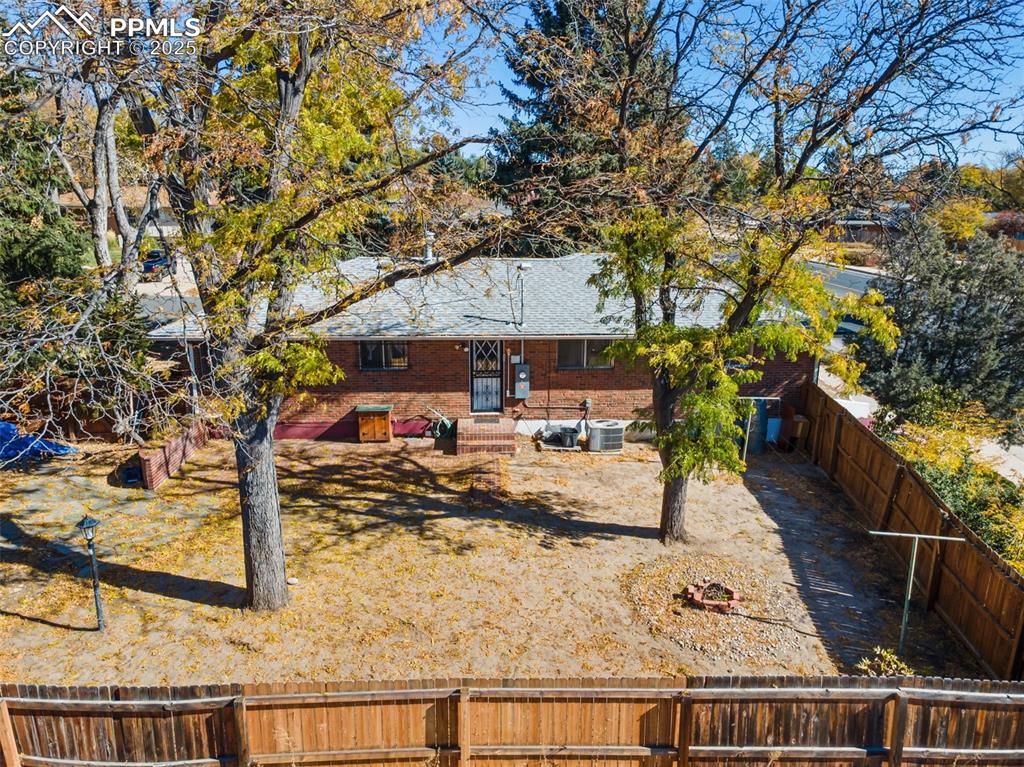 Rear view of house featuring a fenced backyard and brick siding
