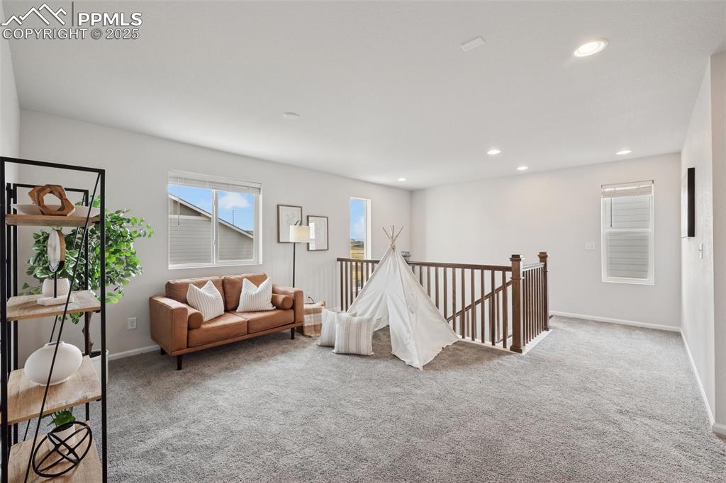 Sitting room featuring an upstairs landing, carpet, and recessed lighting