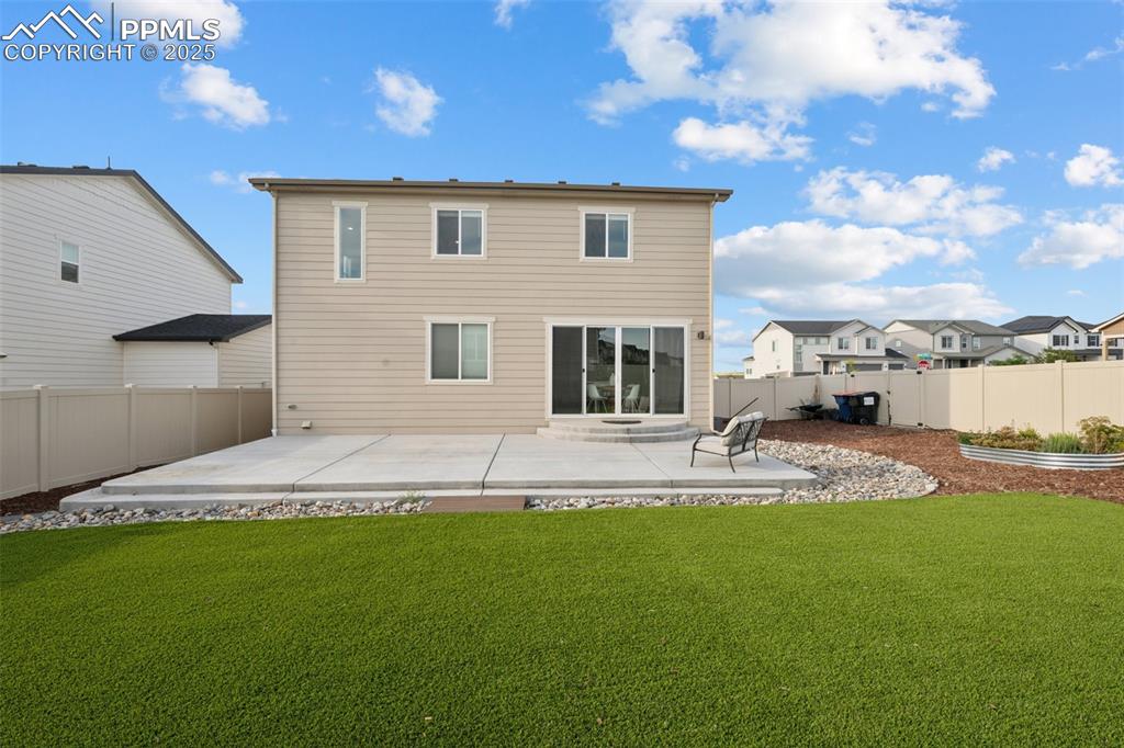 Back of property featuring a patio, turf and a fenced backyard