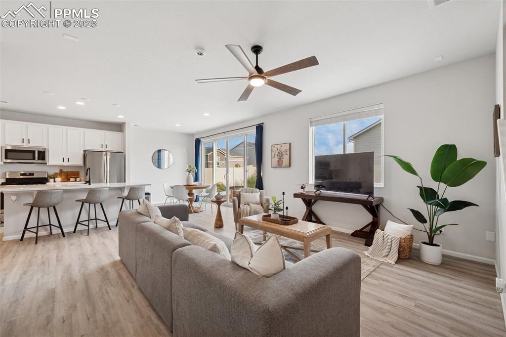 Living area featuring ceiling fan, light wood-style floors, and recessed lighting