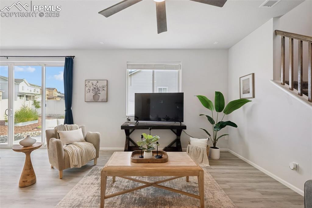 Living area with light wood finished floors and ceiling fan