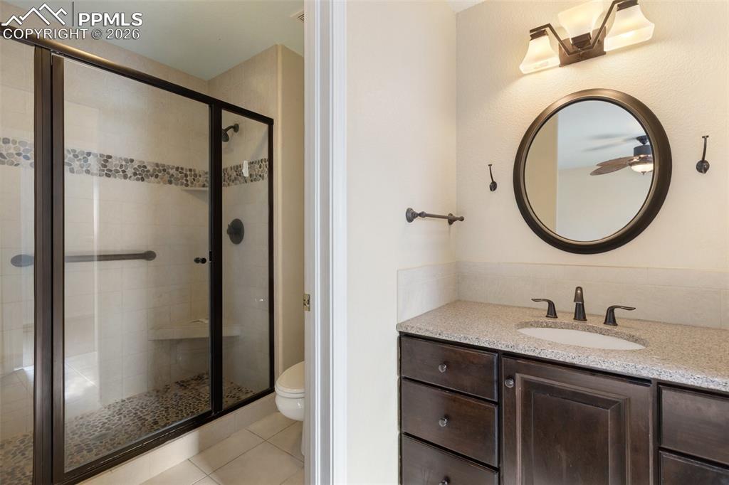 Bathroom featuring a stall shower, vanity, and light tile patterned floors
