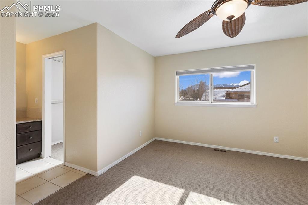 Unfurnished room with light colored carpet and a ceiling fan