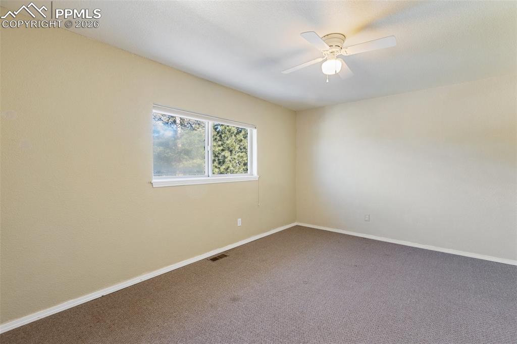 Empty room featuring carpet and ceiling fan