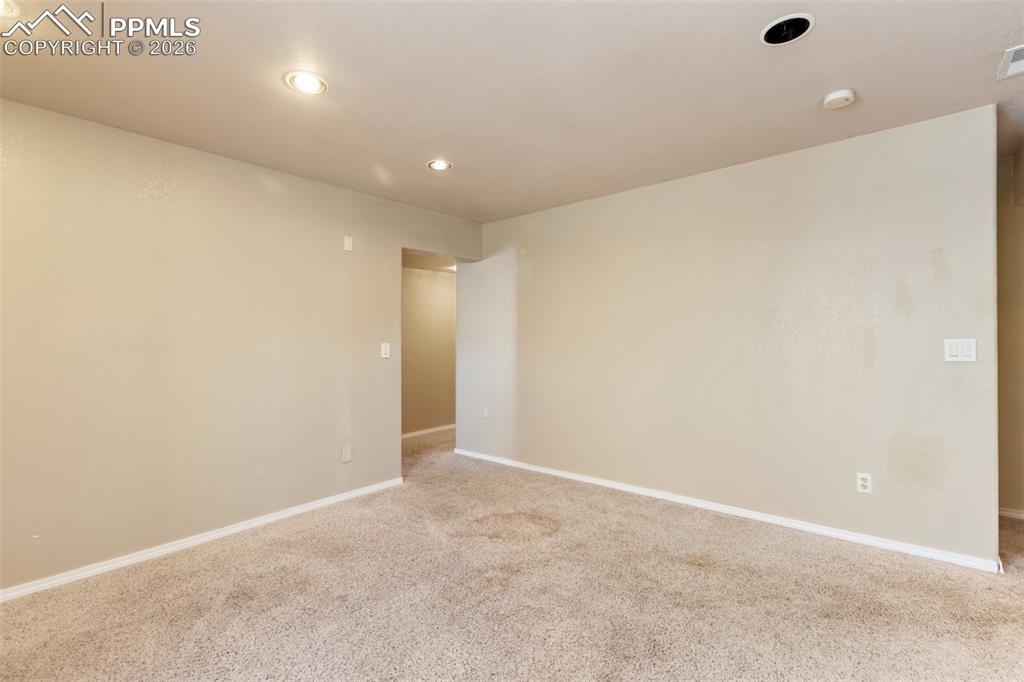 Carpeted spare room featuring baseboards and recessed lighting