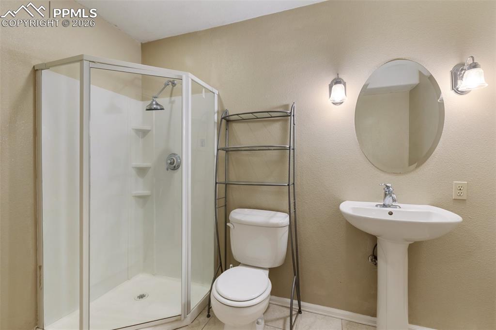 Full bath featuring a stall shower and a textured wall