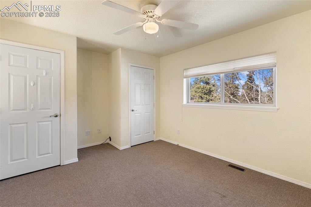 Unfurnished bedroom with carpet flooring and ceiling fan