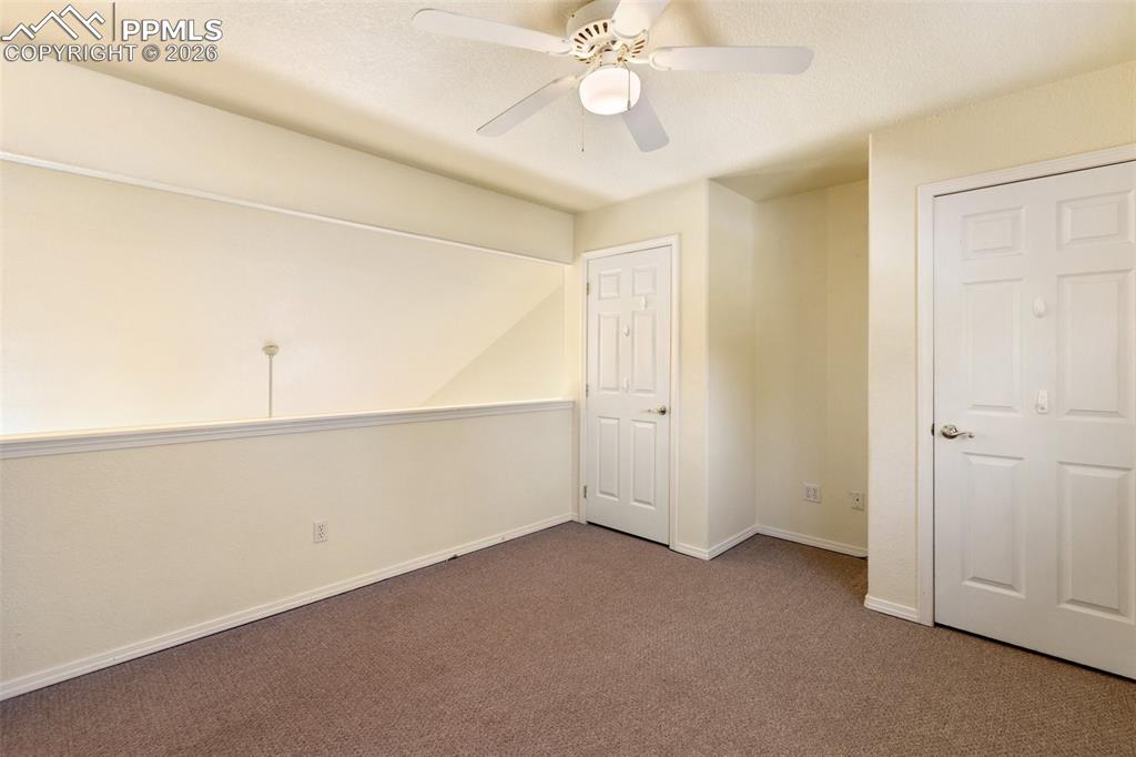 Spare room with ceiling fan and carpet floors