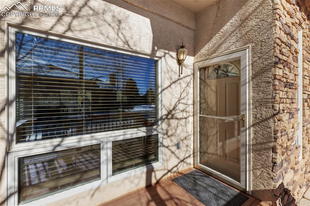 Doorway to property featuring stucco siding