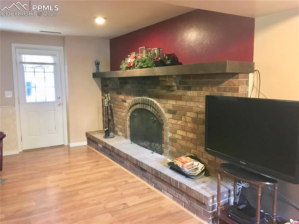 Lower level family room with brick wood-burning fireplace offers access to the backyard.