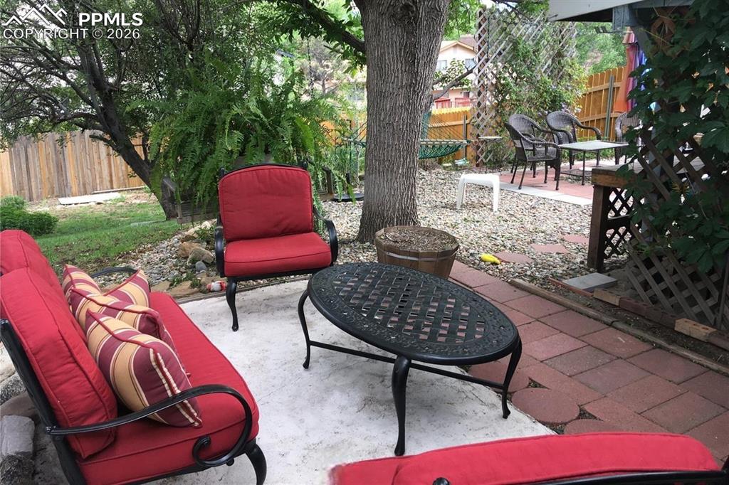 Attractive patio area in the backyard is shaded by mature trees.