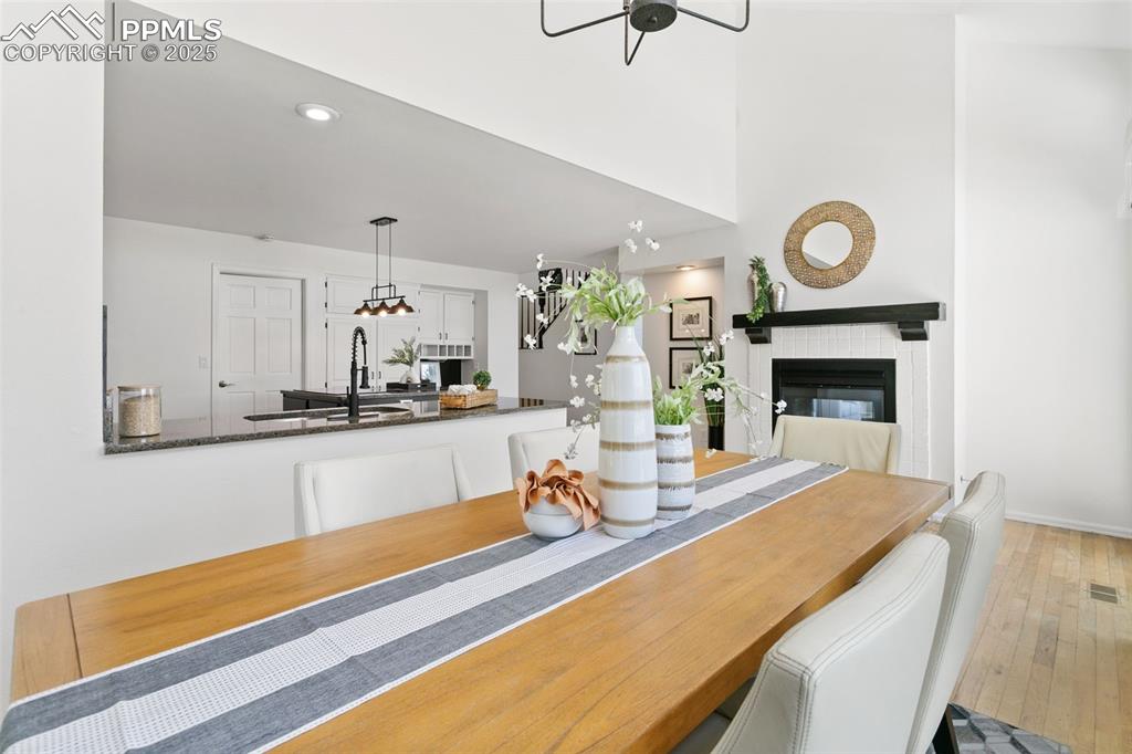 Dining area with a fireplace, wood-type flooring, and recessed lighting