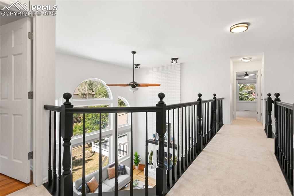 Hall with an upstairs landing and carpet flooring