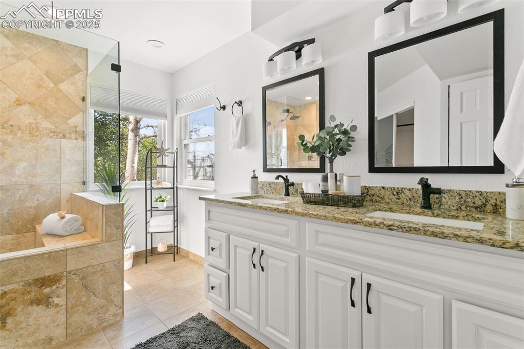 Bathroom featuring double vanity, a tile shower, tile patterned floors, and recessed lighting