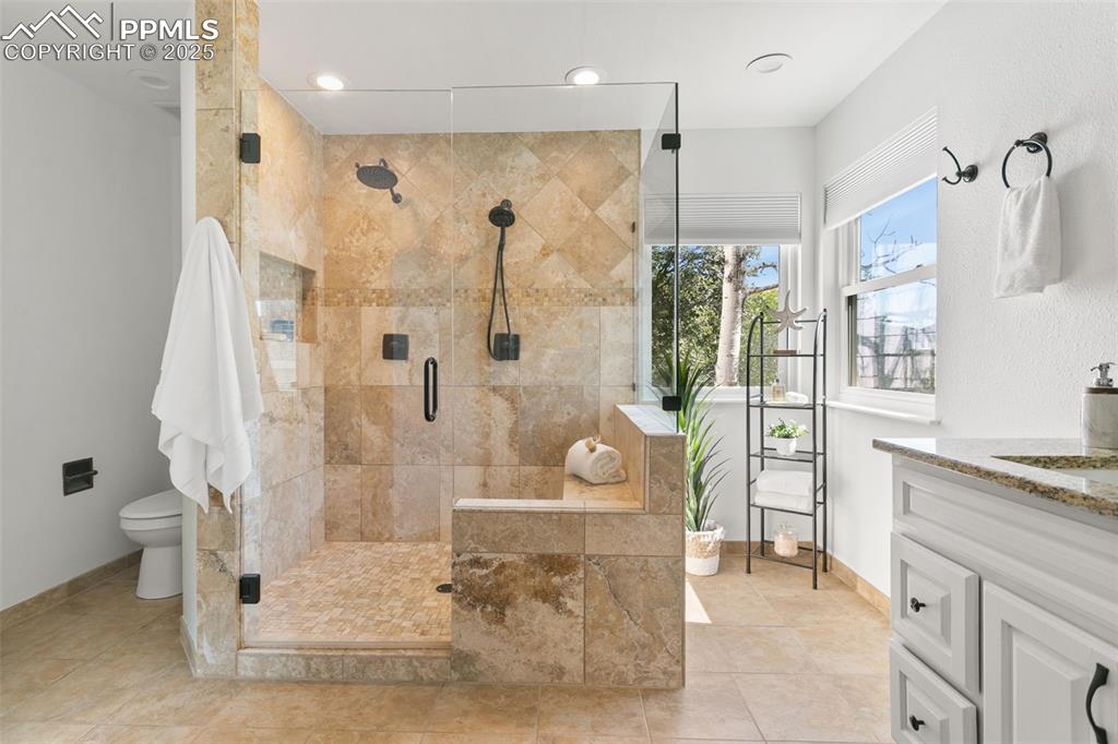 Full bathroom featuring vanity, a shower stall, tile patterned flooring, and recessed lighting