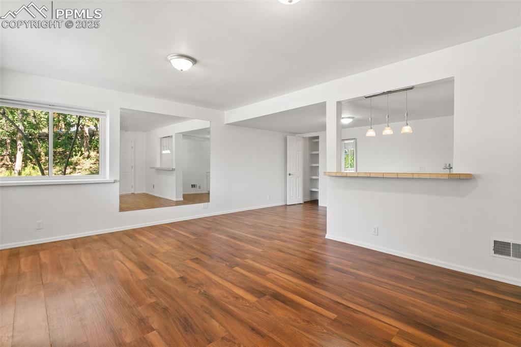 Unfurnished living room featuring plenty of natural light and wood finished floors