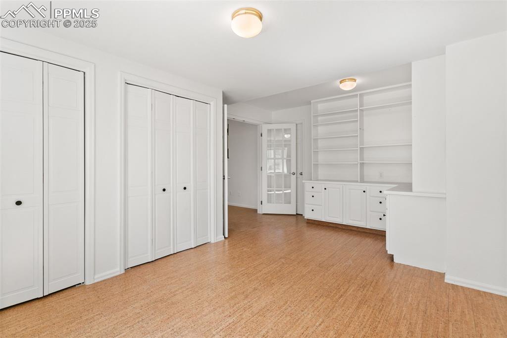 Unfurnished bedroom featuring two closets and light wood-style floors