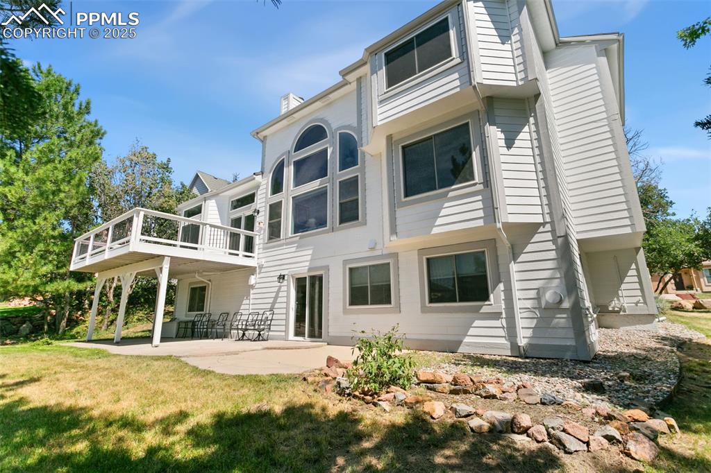 Back of house featuring a patio, a yard, and a chimney