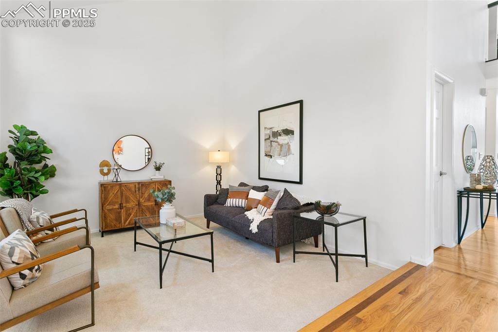 Living room featuring a towering ceiling and light wood-style flooring