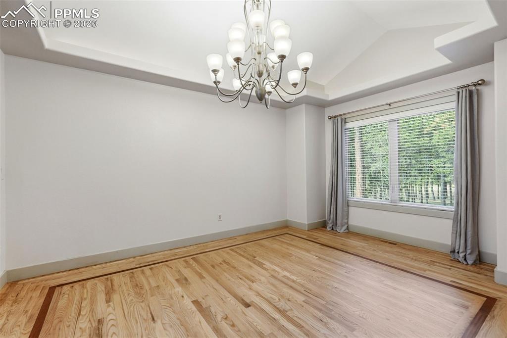Formal Elegant Dining Room featuring a tray ceiling, wood-flooring, chandelier