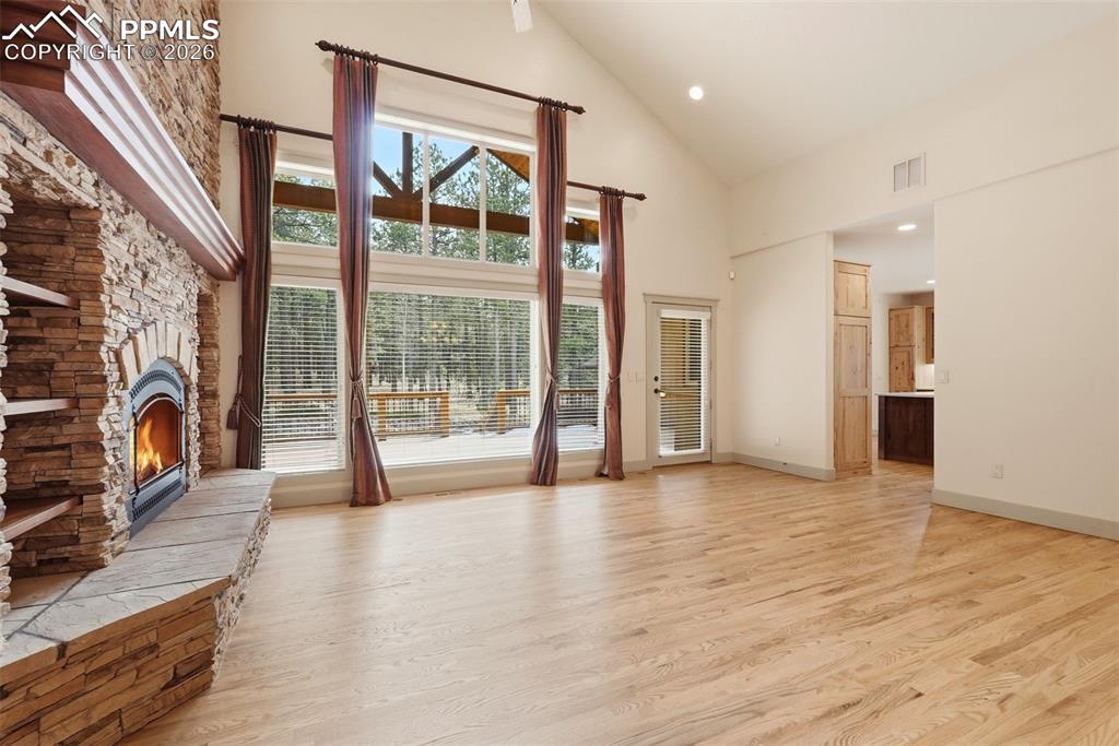 Vaulted Living room with a fireplace stone hearth, wood floors, and prewired for speakers