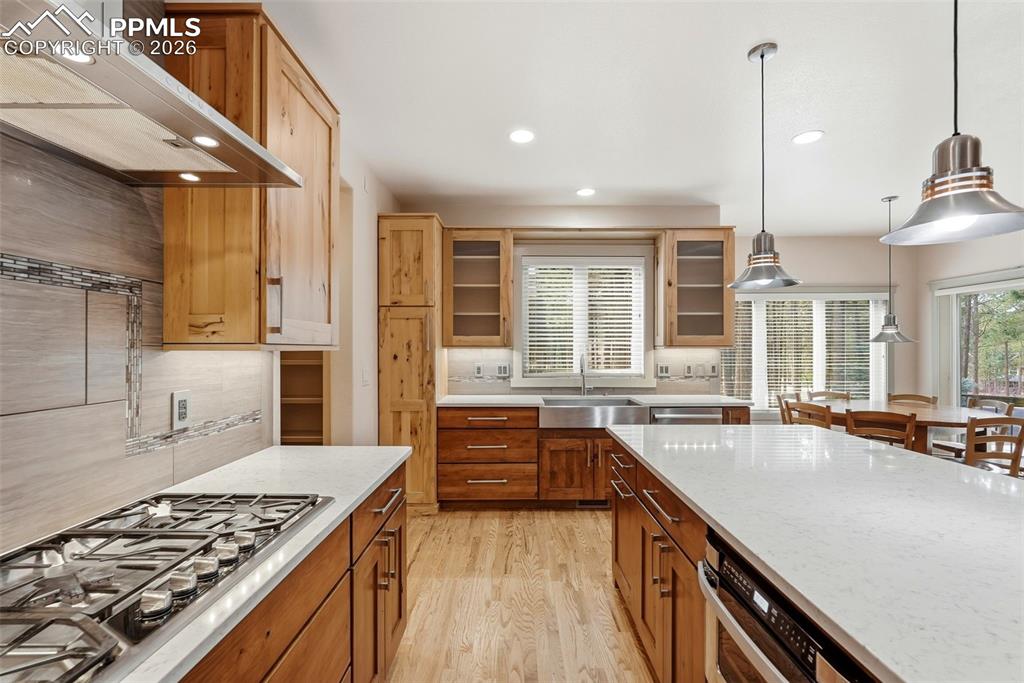 Ga range, luxury stainless steel appliances,tasteful backsplash, and light stone counters