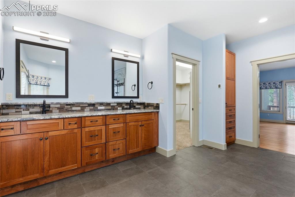 Full bath with double vanity, backsplash, and recessed lighting