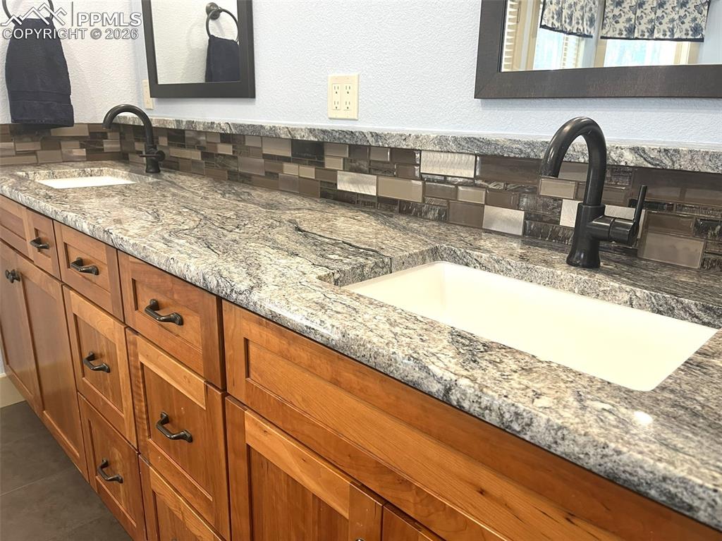 Bathroom featuring double vanity and a textured wall